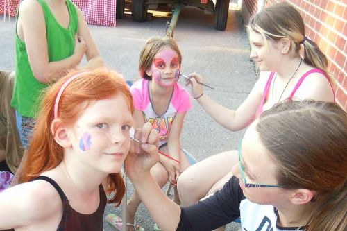 Sydenham High School students Cassie White and Kira Janusz paint Hope and Addison's faces at Panther Palooza